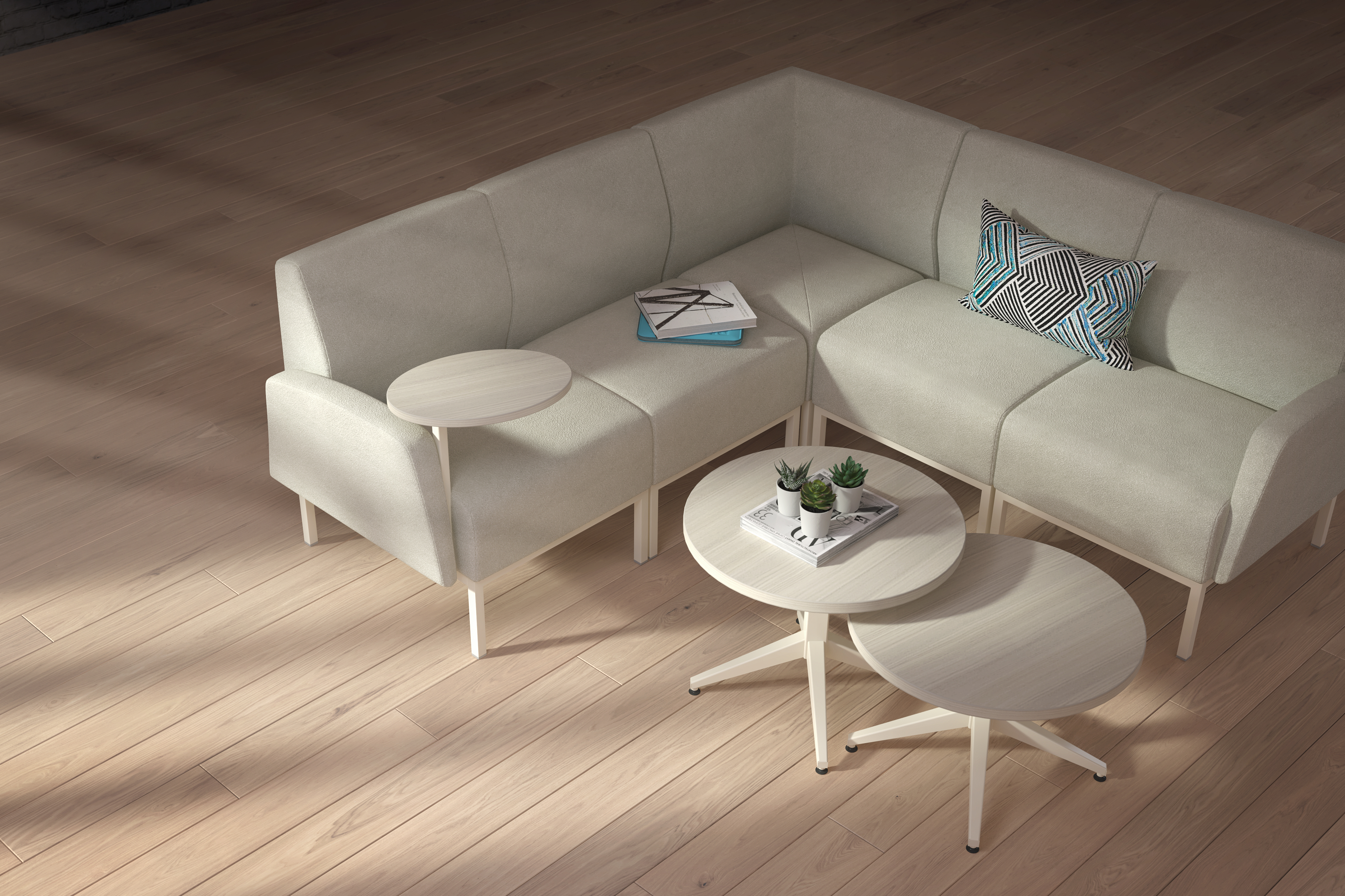 grey modular couch in a l-shape configuration, with a round top nested coffee tables